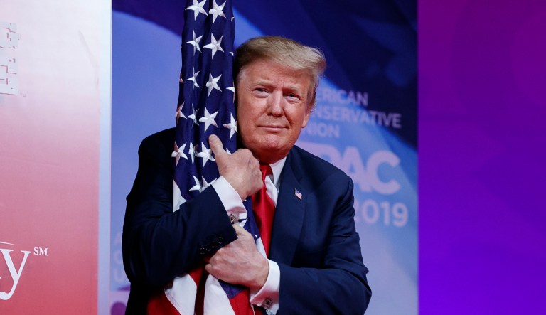 President Donald Trump hugs the American flag as he arrives to speak at the Conservative Political Action Conference, CPAC 2019. Liberal Bill Maher frets that if Trump loses the election he won't leave the White House.
