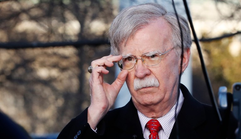 Former national security adviser John Bolton adjusts his glasses.