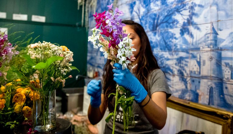 MJ Javan, prepares bouquets of flowers at the flower shop âShe Loves Me DCâ after they received an influx of orders during the coronavirus epidemic, Friday, March 20, 2020, in Washington. Owner Holley Simmons said she has received over 300 orders, which is more then four times the number of orders they received for Valentines Day.
