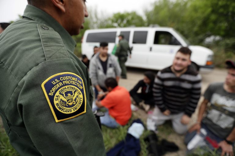 In this Thursday, March 14, 2019 photo, a Border Patrol agent talks with a group suspected of having entered the U.S. illegally near McAllen, Texas. The administration shut down the nation's asylum system for the first time in decades amid coronavirus concerns, largely because holding people in custody is considered too dangerous.