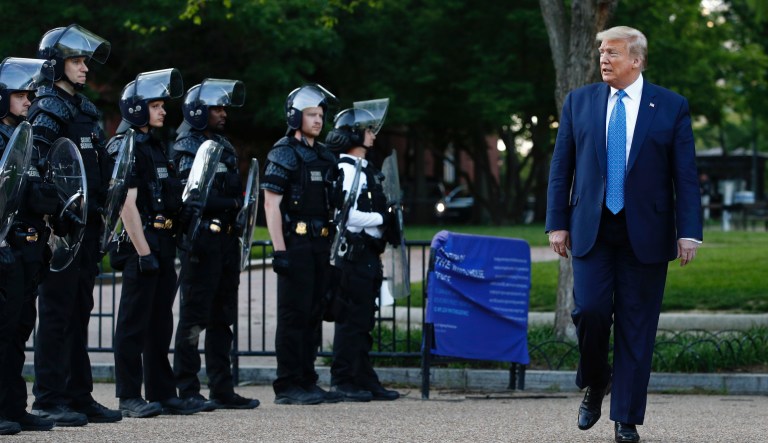 President Donald Trump walks past police in Lafayette Park after visiting outside St. John's Church across from the White House Monday, June 1, 2020, in Washington. Part of the church was set on fire during protests on Sunday night.
