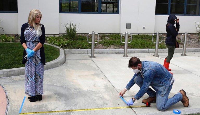 FILE - In this Sunday, April 5, 2020 file photo, a distance is measured as worshippers line up to take communion on Palm Sunday outside of Godspeak Calvary Chapel in Newbury Park, Calif. Churches in California and Minnesota, backed by a conservative legal group, have file lawsuits in August 2020 against the governors of their states challenging restrictions imposed due to the coronavirus outbreak that they contend are violations of religious liberty.