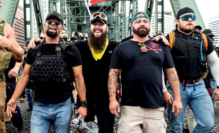 Proud Boys Chairman Enrique Tarrio (left) and other right-wing demonstrators march across the Hawthorne Bridge during an 