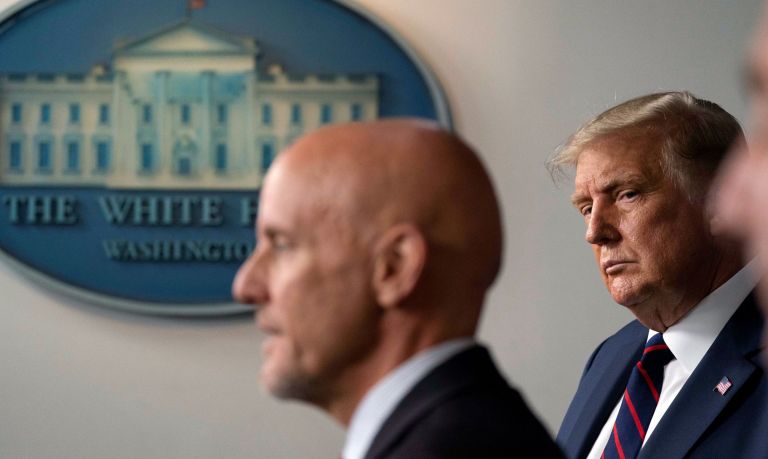 In this file photo President Donald Trump, listens as Food and Drug Administration Commissioner Dr. Stephen Hahn, left, speaks during a media briefing in the James Brady Briefing Room of the White House in Washington
