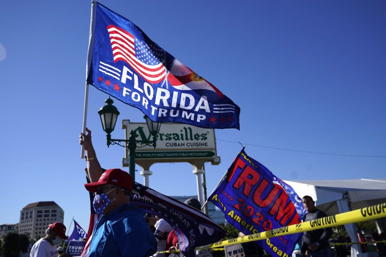 Hernan Reyes waves a flag in support of President Donald Trump during a rally outside of Versailles Restaurant, Wednesday, Jan. 6, 2021, in Miami. Florida is now home to his movement.
