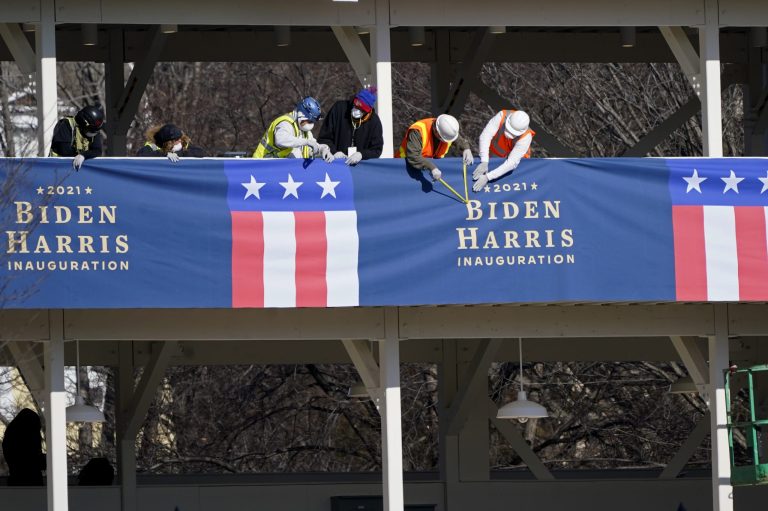 Workers put up bunting on a press riser for the upcoming inauguration of President-Elect Biden and Vice President-Elect Kamala Harris, on Pennsylvania Avenue in front of the White House.