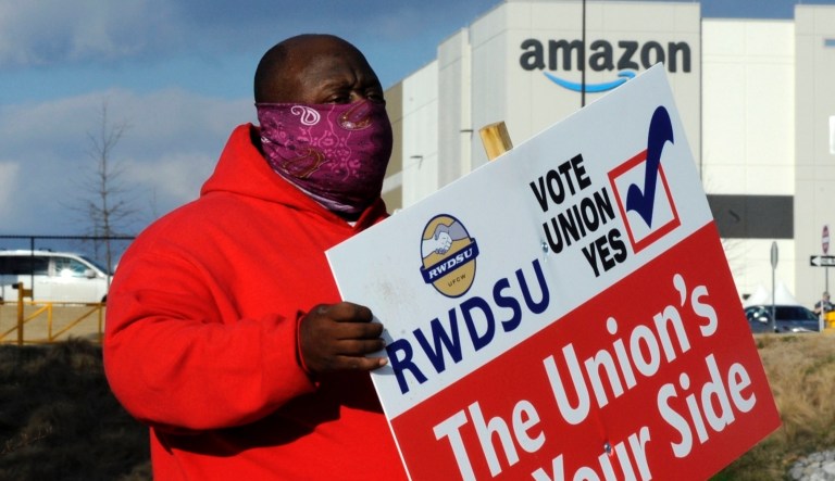 Michael Foster from an Amazon Labor Union holds a sign outside an Amazon facility where labor is trying to organize workers on Tuesday, Feb. 9, 2021. President Joe Biden said workers in Alabama and across the country have the right to join a union without intimidation from their companies. His comments come as Amazon workers in the state are voting on whether they should unionize. 