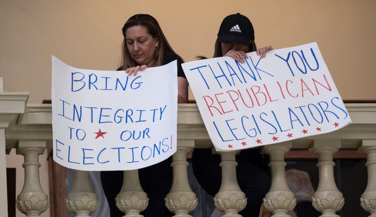 Protesters in favor of changes in Georgiaâs voting laws hold signs inside the State Capitol in Atlanta, Ga., as the Legislature meets Monday, March 8, 2021.