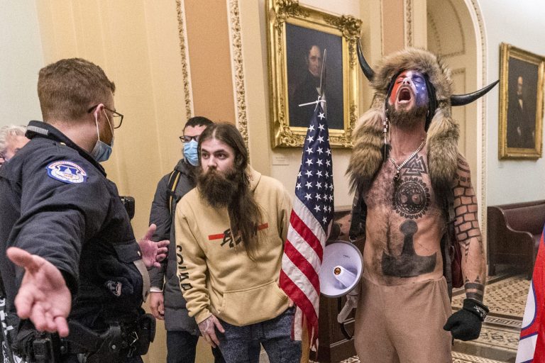 In this Jan. 6, 2021 file photo, supporters of President Donald Trump, including Jacob Chansley, right with fur hat, are confronted by U.S. Capitol Police officers outside the Senate Chamber inside the Capitol in Washington.