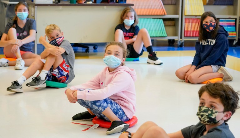 In this May 18, 2021 file photo, fifth graders wear face masks are seated at proper social distancing spacing during a music class at the Milton Elementary School in Rye, N.Y.  As more children go back to the physical classroom, families are expected to spend robustly on a wide range of items, particularly  trendy clothing for the critical back-to-school season, according to one key spending measure.