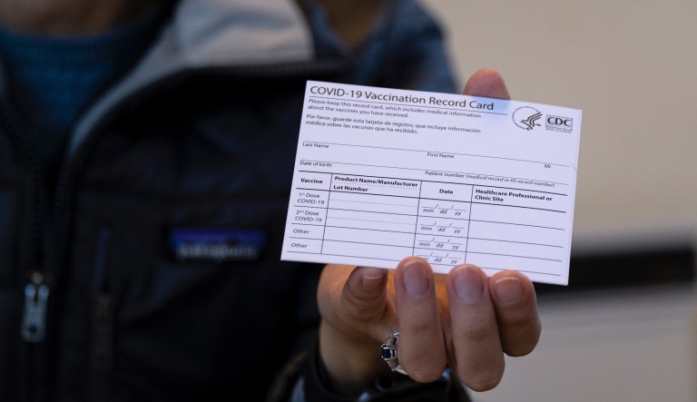 In this Jan. 10, 2021 file photo, Sarah Gonzalez of New York, a Nurse Practitioner, displays a COVID-19 vaccine card at a New York Health and Hospitals vaccine clinic in the Brooklyn borough of New York.