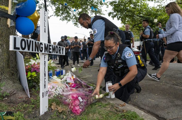 Chicago police officers leave flowers at a memorial for slain officer Ella French at 63rd and Bell, Monday, Aug. 9, 2021, in Chicago. French was shot and killed during a traffic stop near the site Saturday, Aug. 7.  (Tyler LaRiviere/Chicago Sun-Times via AP) 