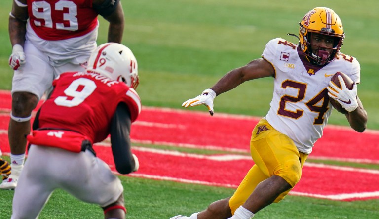 Minnesota running back Mohamed Ibrahim (24) carries the ball away from Nebraska safety Marquel Dismuke (9), during the second half of an NCAA college football game in Lincoln, Neb., Saturday, Dec. 12, 2020. Minnesota won 24-17. 