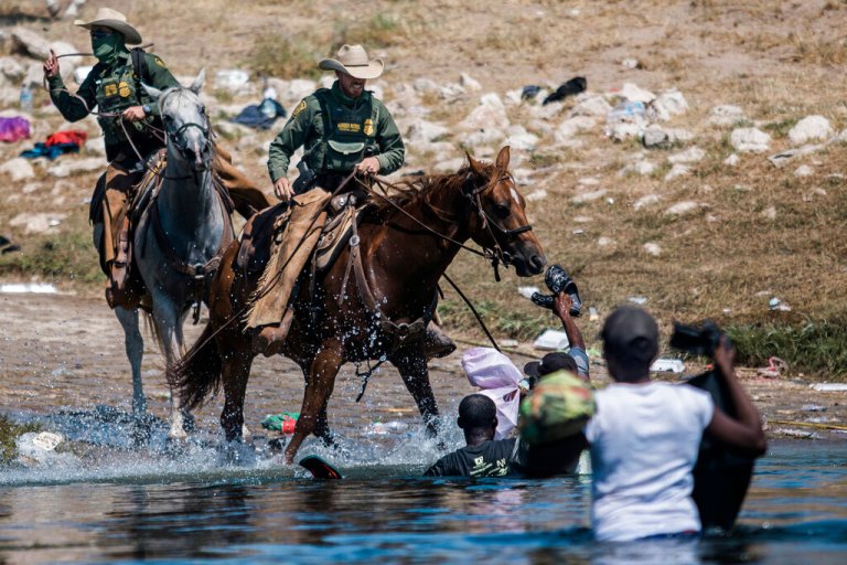 Mounted Border Patrol agents attempt to contain migrants as they cross the Rio Grande.