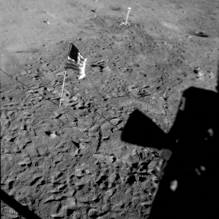 This July 21, 1969 photo made available by NASA shows a U.S. flag planted at Tranquility Base on the surface of the moon and a silhouette of a thruster at right, seen from a window in the Lunar Module. On Tuesday, Nov. 9, 2021, NASA announced it is delaying putting astronauts back on the moon until 2025 at the earliest. (NASA via AP)