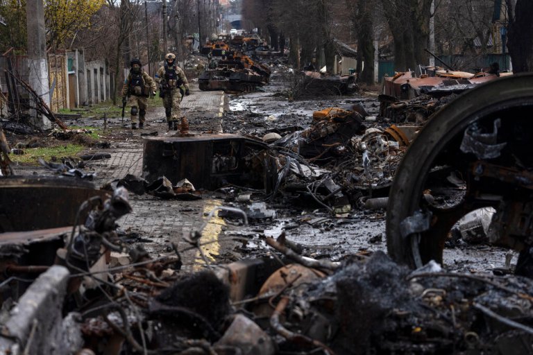 Soldiers walk amid destroyed Russian tanks in Bucha, on the outskirts of Kyiv, Ukraine, Sunday, April 3, 2022. 