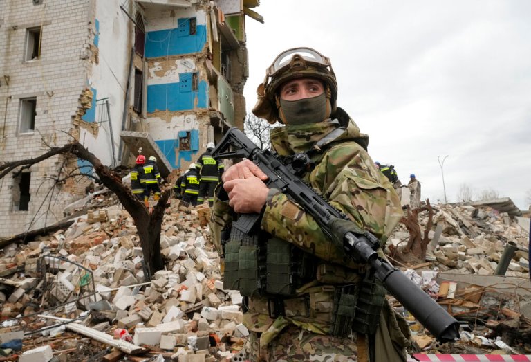 A Ukrainian soldier stands near an apartment ruined by Russian shelling in Borodyanka, Ukraine, Wednesday.