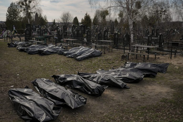 Bodies retrieved by municipal workers from the town are placed at a cemetery in Bucha, Ukraine, on Thursday, April 7, 2022. Russian troops left behind crushed buildings, streets littered with destroyed cars, and residents in dire need of food and other aid in a northern Ukrainian city, fueling Kyiv's calls for more Western support to help halt Moscow's offensive before it refocuses on the country's east. 