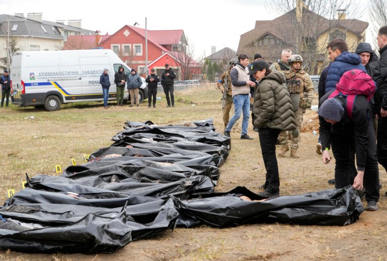 FILE - Ukrainian Prosecutor General Iryna Venediktova, center, looks at the exhumed bodies of civilians killed during the Russian occupation in Bucha, on the outskirts of Kyiv, Ukraine, Friday, April 8, 2022.