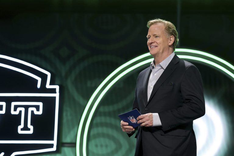 NFL Commissioner Roger Goodell walks onstage with a pick during the first round of the 2022 NFL Draft.