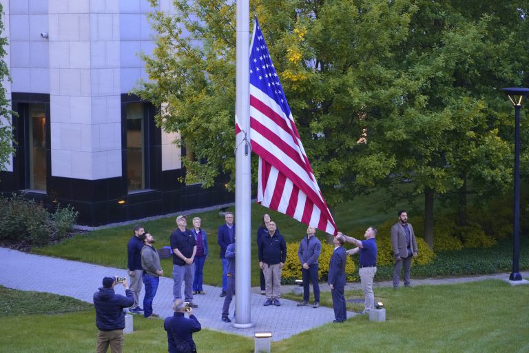 Employees of US embassy in Ukraine raise the US national flag at the US embassy, as Russia's attack on Ukraine continues, in Kiev, Ukraine, Wednesday, May 18, 2022. (AP Photo/Efrem Lukatsky)