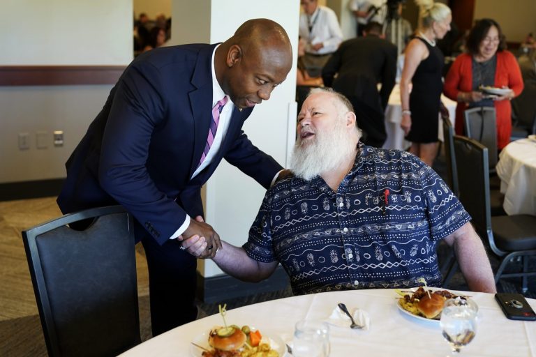 Sen. Tim Scott, R-S.C., talks with Randy Millam, of Lowden, Iowa, right, during an Iowa GOP reception in Cedar Rapids, Iowa. 