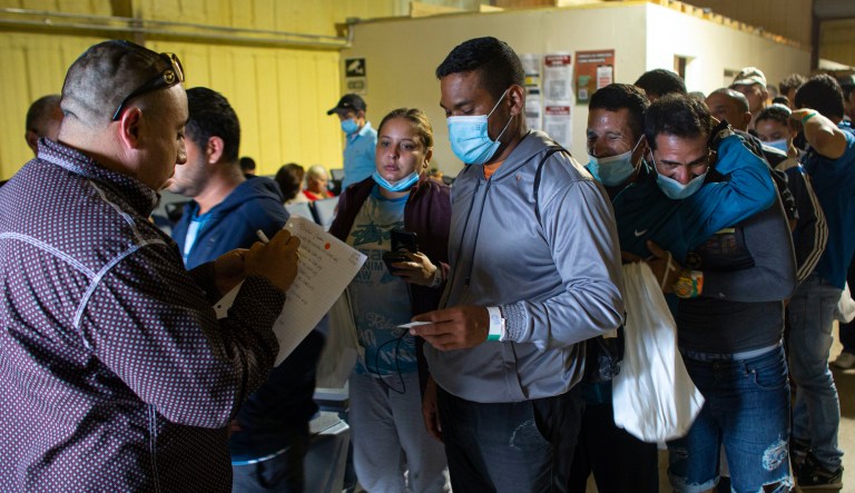 People line up for a commercial bus that will take them to the San Antonio airport at a warehouse run by the Mission: Border Hope nonprofit group run by the United Methodist Church in Eagle Pass, Texas, on May 23. The Border Patrol releases up to 1,000 migrants daily at Mission: Border Hope. The nonprofit group outgrew a church and moved to the warehouse in April amid the Biden administration's rapidly expanding practice of releasing migrants on parole, particularly those who are not subject to a pandemic rule that prevents migrants from seeking asylum.
