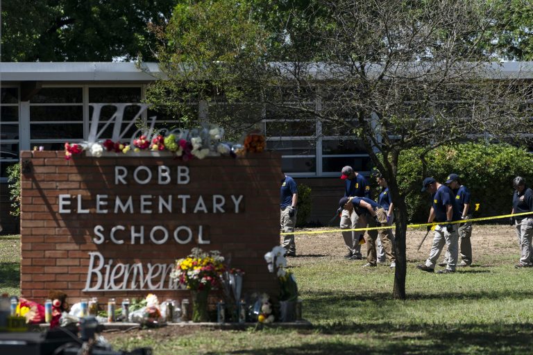 FILE - Investigators search for evidences outside Robb Elementary School in Uvalde, Texas, May 25, 2022, after an 18-year-old gunman killed 19 students and two teachers. The shooter's 66-year-old grandmother was discharged from a hospital on June 28, 2022.  (AP Photo/Jae C. Hong, File)