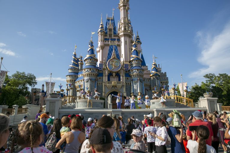 Walt Disney World Resort visitors watch as Mickey Mouse, Minnie Mouse, Goofy, Donald Duck, and Daisy Duck perform in front of Cinderella's Castle, in April 2022. 
