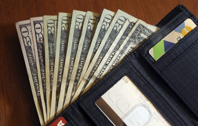 FILE - In this June 15, 2018, file photo, cash is fanned out from a wallet in North Andover, Massachusetts. (AP Photo/Elise Amendola, File)
