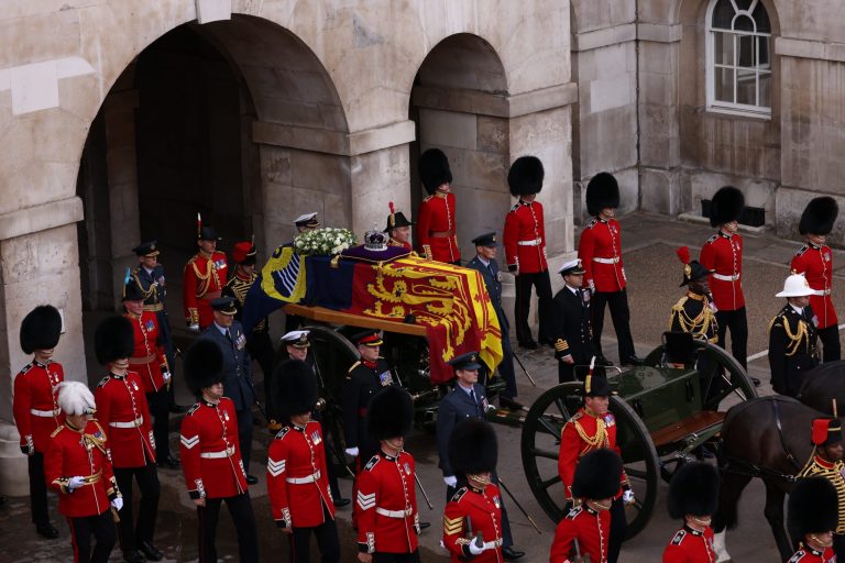 Members of the armed forces move the coffin of Queen Elizabeth II, adorned with a Royal Standard and the Imperial State Crown, during a procession from Buckingham Palace to Westminster Hall in London on Sept. 14, 2022. The Queen will lie in state in Westminster Hall for four full days before her funeral on Sept. 19. 