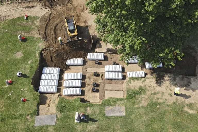 In this aerial photo, a mass grave is refilled with dirt after a small ceremony at Oaklawn Cemetery, Friday, July 30, 2021, in Tulsa, Oklahoma. The mass grave was discovered while searching for victims of the Tulsa Race Massacre. 