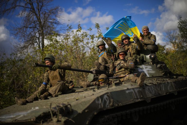 FILE - Ukrainian soldiers sit on an armoured vehicle as they drive on a road between Izium and Lyman, recently retaken areas in Ukraine, on Oct. 4, 2022. (AP Photo/Francisco Seco, File)