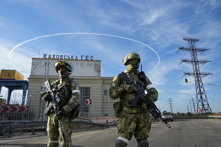 Russian troops guard an entrance of the Kakhovka Hydroelectric Station, a run-of-river power plant on the Dnieper River in Kherson region, south Ukraine, on May 20, 2022. This photo was taken during a trip organized by the Russian Ministry of Defense.
