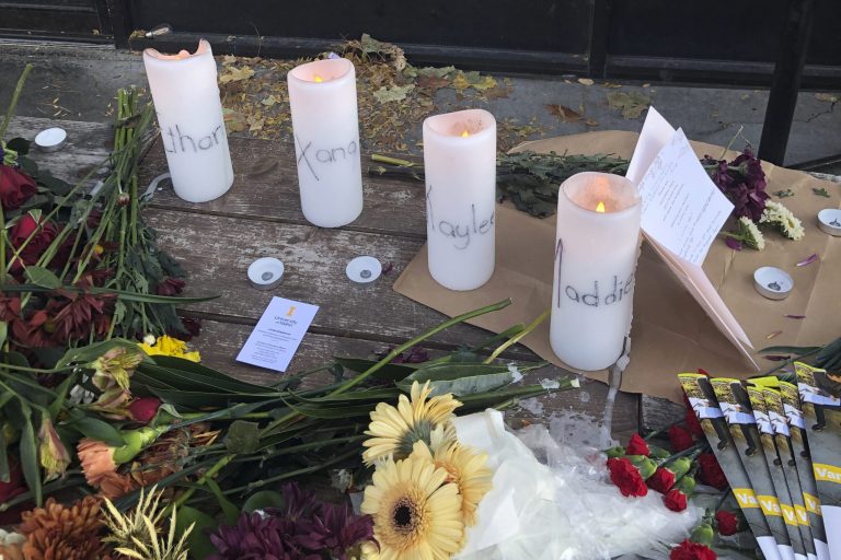 Candles and flowers are left at a make-shift memorial honoring four slain University of Idaho students outside the Mad Greek restaurant in downtown Moscow, Idaho.