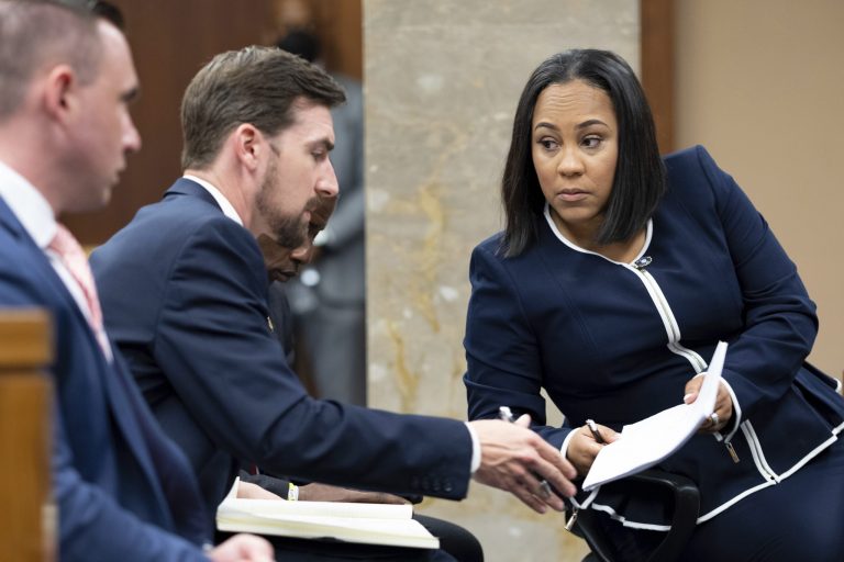 Fulton County District Attorney Fani Willis, right, talks with a member of her team during proceedings to seat a special purpose grand jury in Fulton County, Georgia, on May 2, 2022, to look into the actions of former President Donald Trump and his supporters who tried to overturn the results of the 2020 election.