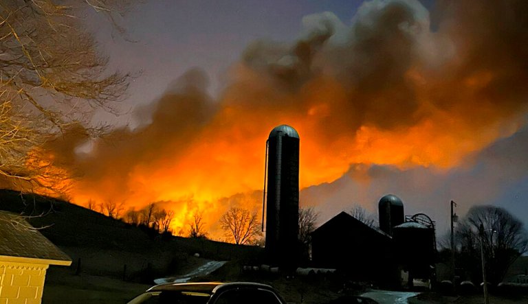 In this photo provided by Melissa Smith, a train fire is seen from her farm in East Palestine, Ohio, Friday, Feb. 3, 2023. 