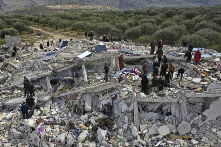 Civil defense workers and residents search through the rubble of collapsed buildings in the town of Harem near the Turkish border.