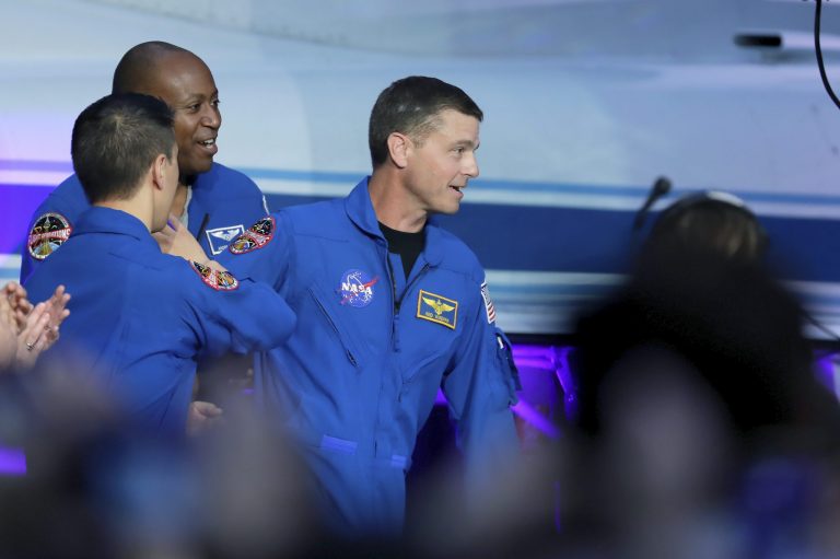 Astronaut Reid Wiseman, center, walks past other astronaut candidates to the stage after he is announced as the mission commander during a NASA ceremony naming the four astronauts who will fly around the moon by the end of next year on the Artemis II mission, at a ceremony held in the NASA hangar at Ellington airport Monday, April 3, 2023, in Houston. 