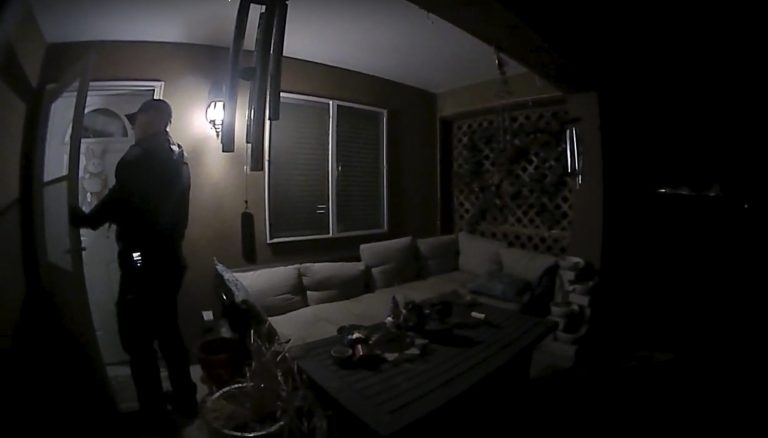 In this image taken from body camera video provided by the Farmington Police Department, a police officer knocks on the door of the wrong address in response to a domestic violence call, in Farmington, New Mexico.