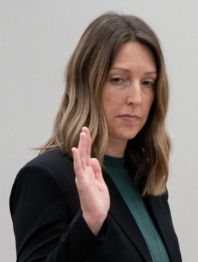 Dr. Caitlin Bernard raises her right hand as she is sworn in Thursday, May 25, 2023, during a hearing in front of the state medical board at the Indiana Government South building in downtown Indianapolis. 