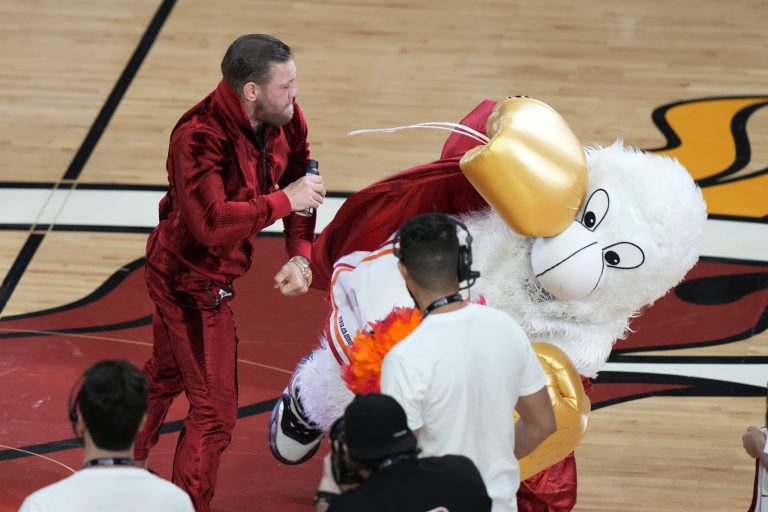 Former MMA fighter Conor McGregor punches Burnie, the Miami Heat mascot, during a break in Game 4 of the basketball NBA Finals against the Denver Nuggets, Friday, June 9, 2023, in Miami. The man who occupies Burnie's costume needed medical attention. 