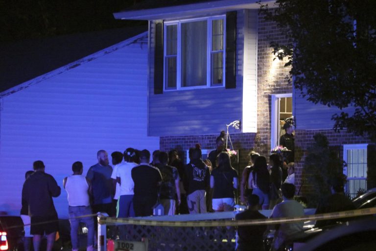 People gather on a residential street in Annapolis, Maryland, where police say multiple people were shot at a home on Sunday, June 11, 2023. 