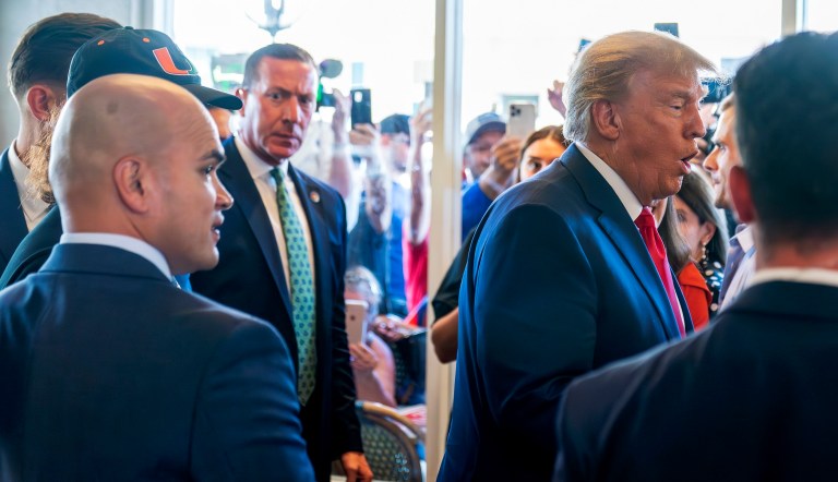 Former President Donald Trump's valet Walt Nauta, left, watches as Trump greets supporters at Versailles restaurant with Trump on Tuesday, June 13, 2023, in Miami. 