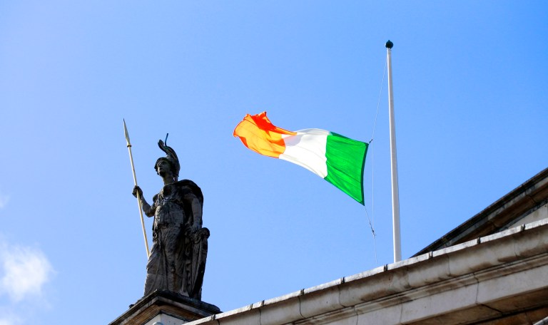 The Irish flag flouts the wind as it flies at half staff over the General Post Office on O'Connell street, Dublin, Ireland, Sunday, March, 27, 2016.  Thousands of people took part in the 100th anniversary of Ireland's Easter Rising against Britain, a doomed rebellion that reduced parts of the capital to ruins and inspired the country's eventual independence.