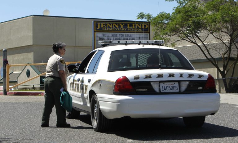 FILE - In this April 29, 2013 file photo, Calaveras County Sheriff's deputies and volunteers stand watch at Jenny Lind Elementary School, after the murder of one it's students over the weekend, in Valley Springs, Calif. Authorities on Saturday, May 11, 2013 arrested the 12-year-old brother of an 8-year-old girl who was mysteriously stabbed at her home in a quiet Northern California community last month. (AP Photo/Rich Pedroncelli, File)