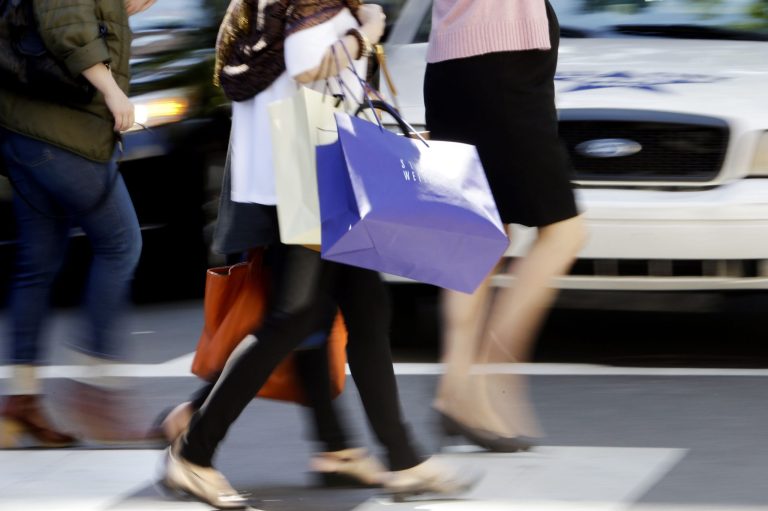   In this Wednesday, Sept. 18, 2013 photo, pedestrians with shopping bags cross a street in Philadelphia. The private Conference Board reports on consumer confidence for September on Tuesday, Sept. 24, 2013. (AP Photo/Matt Rourke)  