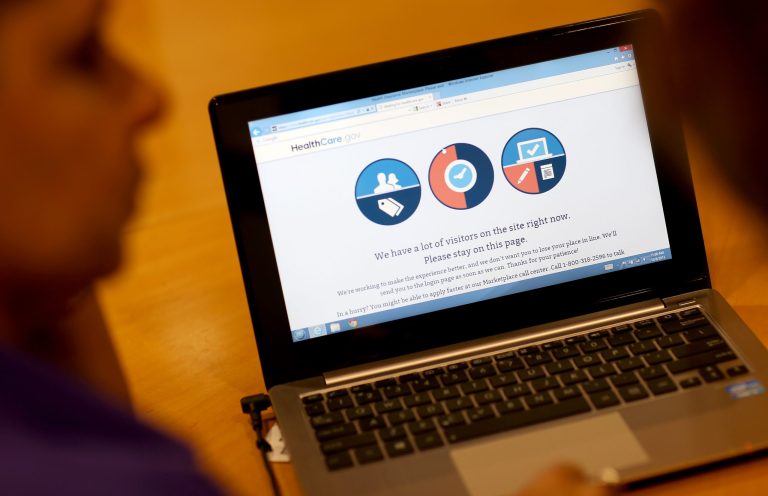 A message is seen on the computer indicating that there are too many visitors on the Affordable Care Act site to continue, as navigator Nini Hadwen helps people shop for health insurance on Oct. 8 in Miami, Florida.  (Joe Raedle/Getty Images)