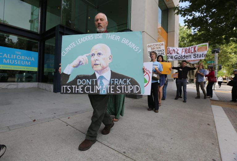 Richard Gray, left,  joins others in a demonstration calling on Gov. Jerry Brown to end hydraulic fracturing for oil and gas, outside the auditorium  where Brown spoke about climate change at the University of California  Giannini Foundation of Agricultural Economics conference in  Sacramento, Calif., Monday, May 19, 2014.(AP Photo/Rich Pedroncelli)