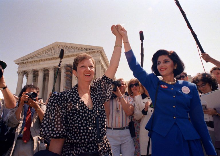 Norma McCorvey, Jane Roe in the 1973 court case, left, and her attorney Gloria Allred hold hands as they leave the Supreme Court building in Washington on April 26, 1989, after the court listened to arguments in a Missouri abortion case. The court's decision may overturn the 1973 Roe v. Wade case which legalized abortion. (AP Photo/J. Scott Applewhite)